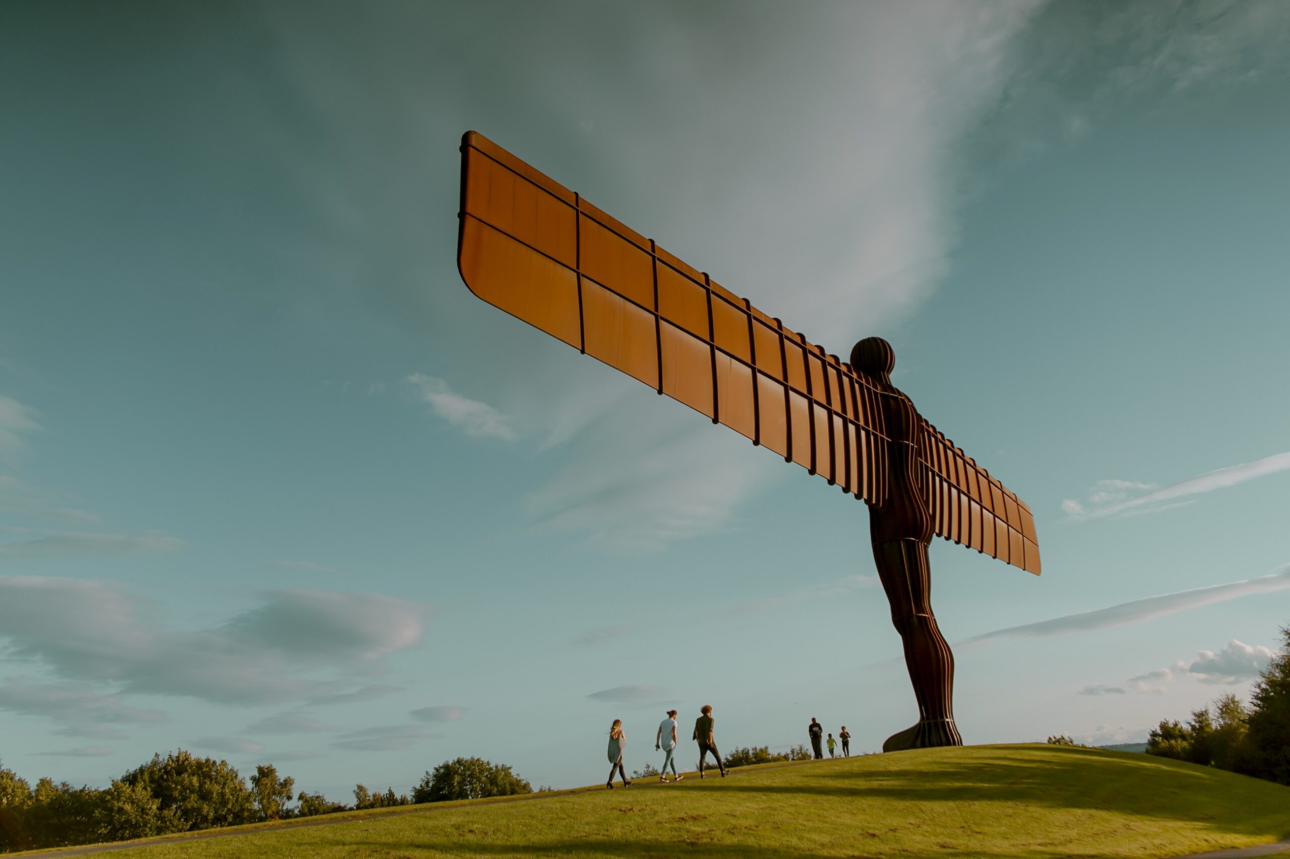 Wooden winged human statue on a hill